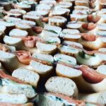 A close-up view of multiple layers of salmon sandwiches, showcasing fresh bread and fillings with a variety of ingredients.
